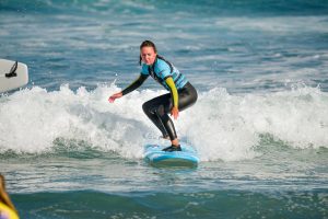 Blackstone Surf Center woman student surfing in Playa las Américas in Tenerife during a surf lesson