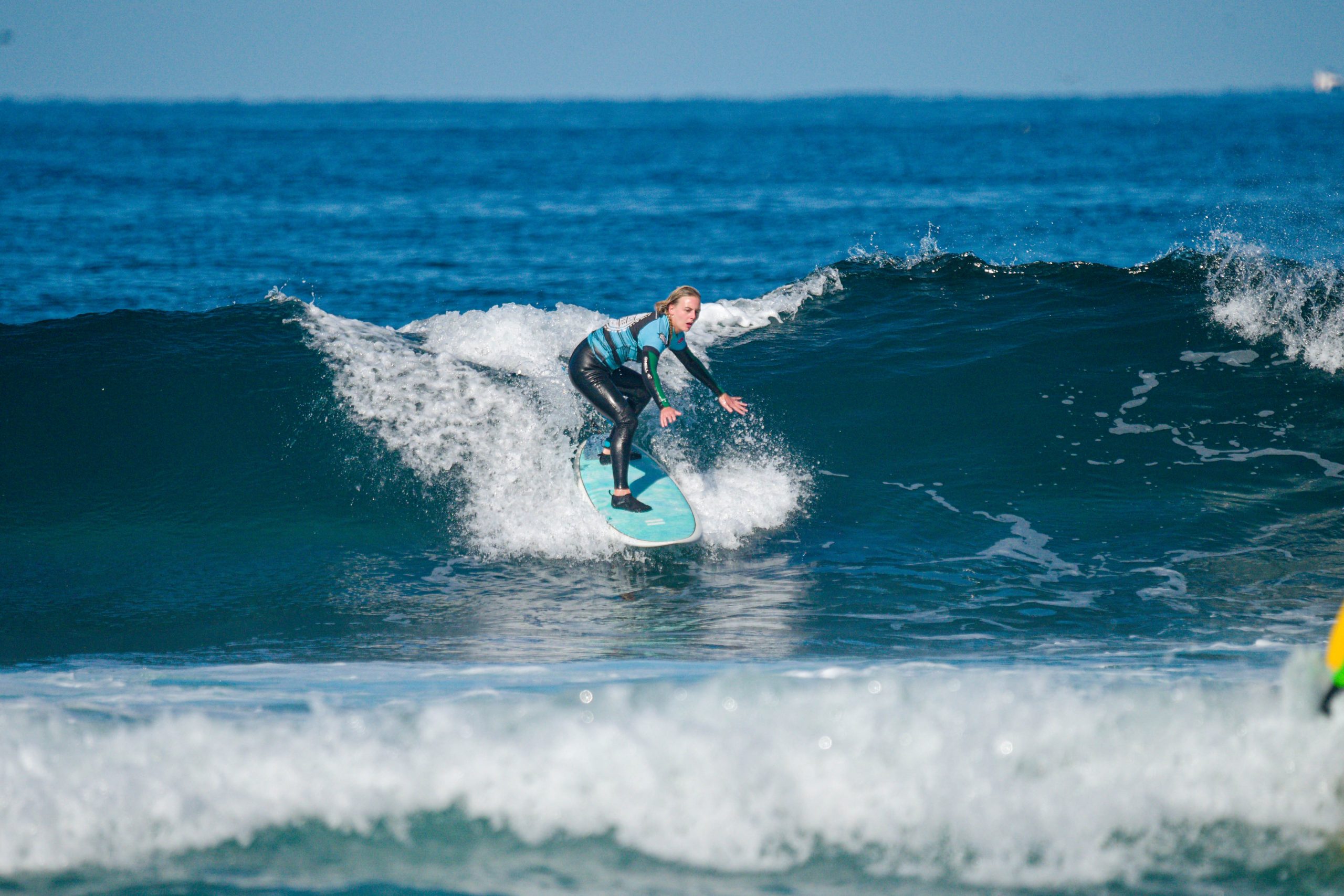 Blackstone Surf Center intermediate student surfing in Playa las Américas in Tenerife during a surf lesson