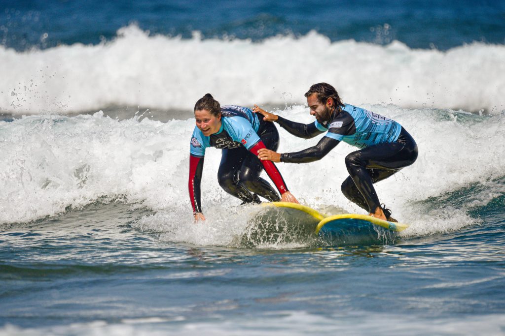 Blackstone Surf Center student surfing with instructor in Playa las Américas in Tenerife during a surf lesson