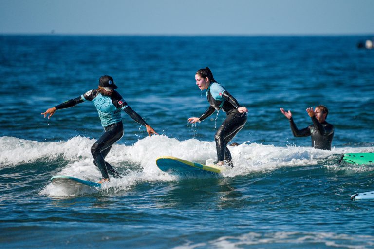 Blackstone Surf Center student surfing with instructor in Playa las Américas in Tenerife during a surf lesson