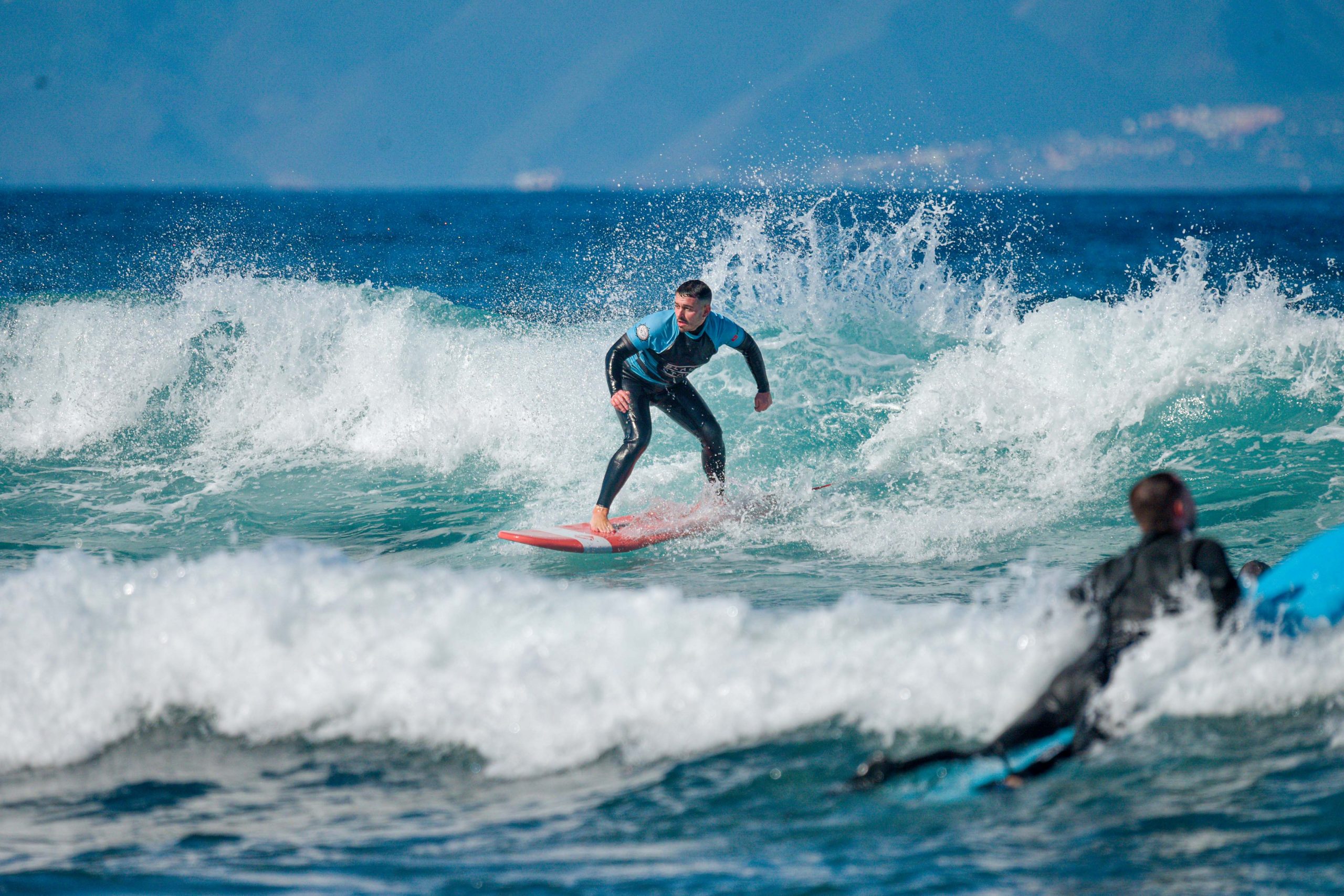 Blackstone Surf Center intermediate male student surfing in Playa las Américas in Tenerife during a surf lesson